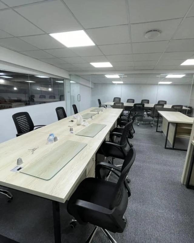 Long bench-style workstations with glass partitions in an open-plan office