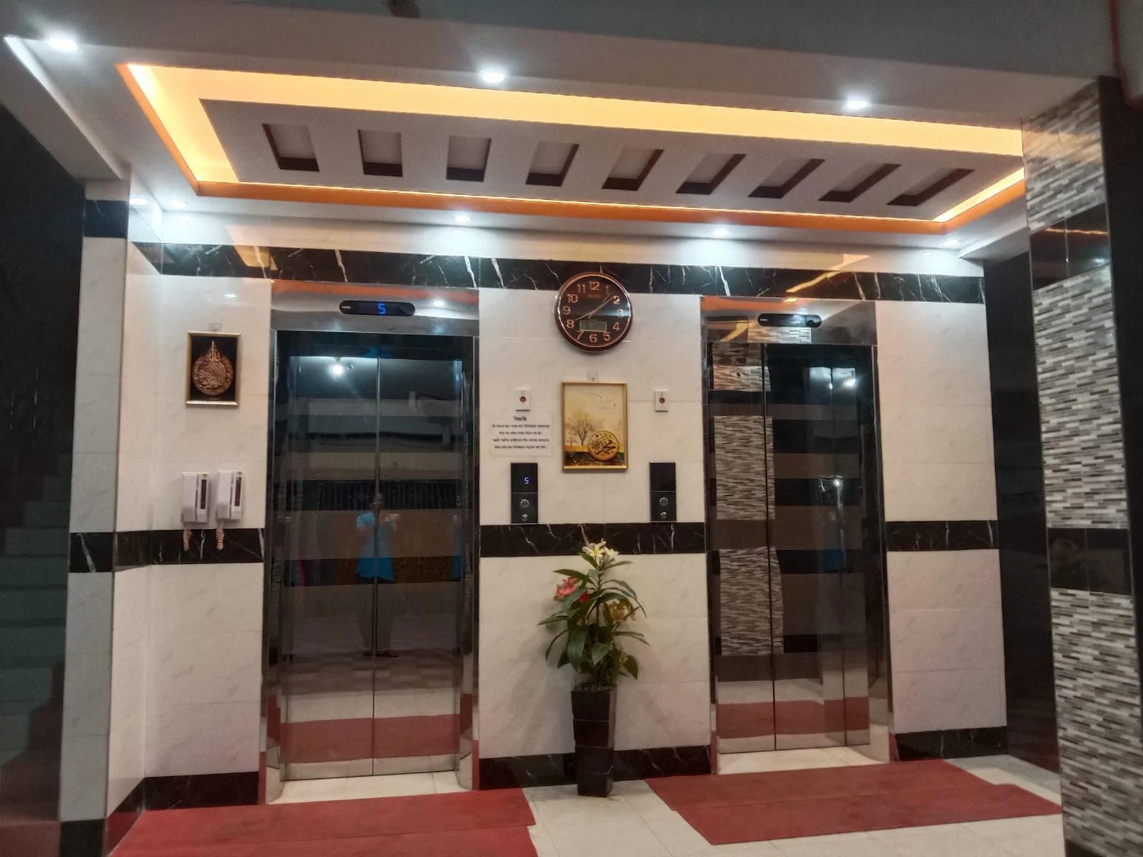 Warm, brass-lit elevator lobby with marble tiling — an interior fit-out by SAZ Commodities u0026amp; Services