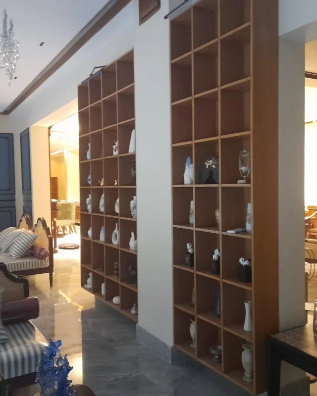 Formal living room with a floor-to-ceiling display shelf and striped upholstered seating