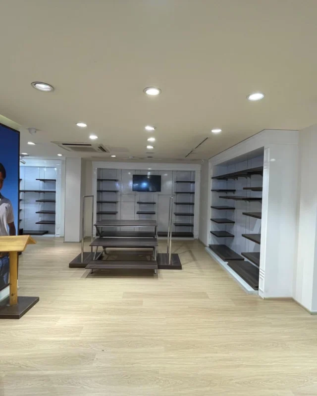 Retail showroom with custom display tables, wall shelving and feature lighting